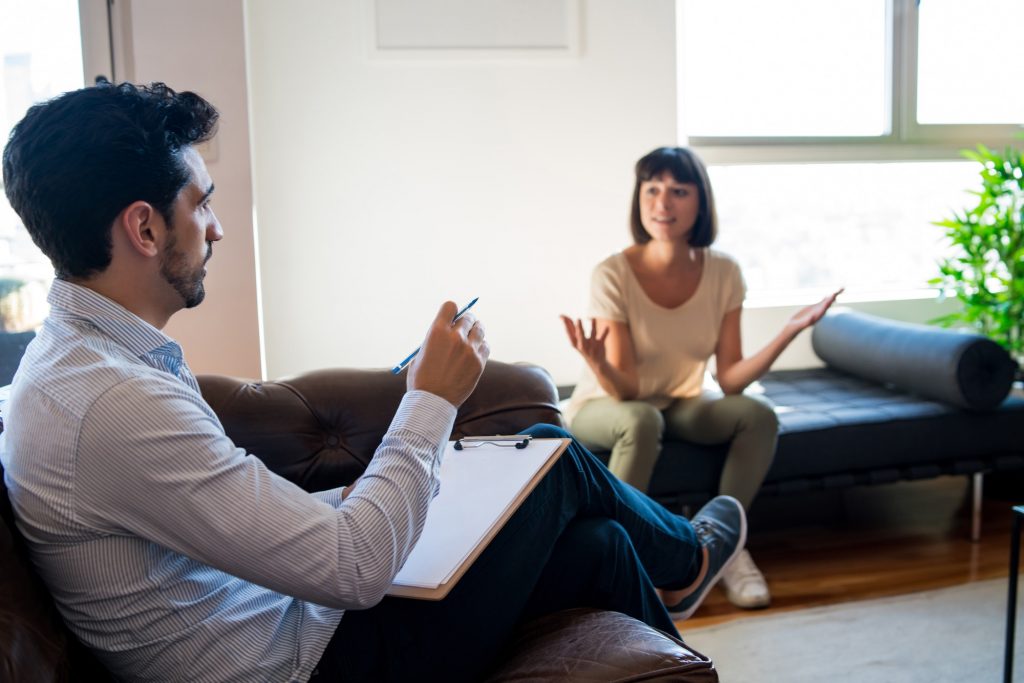 Psychologist talking with patient on therapy session.